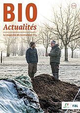 Page de couverture du Bioactualités 3|24: Deux hommes en pleine conversation se tiennent dans un champ, avec des arbres en arrière-plan et un tas de compost au premier plan.