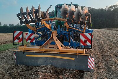 Le cultivateur soulevé derrière le tracteur.