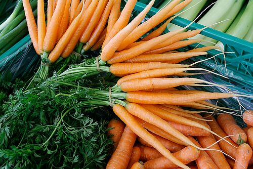 Une botte de carottes dans une caisse de transport.