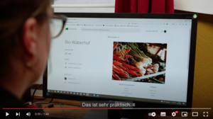 Eine Person sitzt vor einem Laptop mit der Biomondo-Seite. 